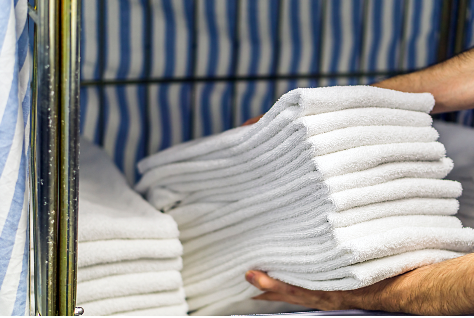 Fresh folded white towels carried to a care-home room